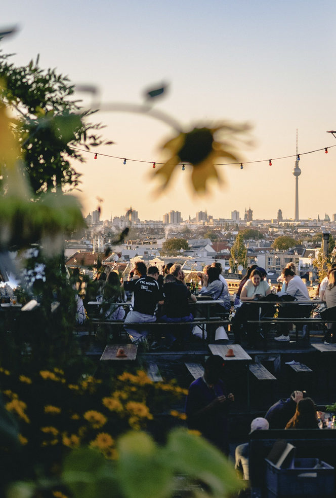 Eine Dachterrasse mit Blick auf Berlin's Dächer. Ballons und Blumen rahmen den Ausblick.